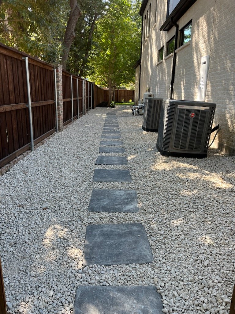 Stepping stones through white gravel beside a house