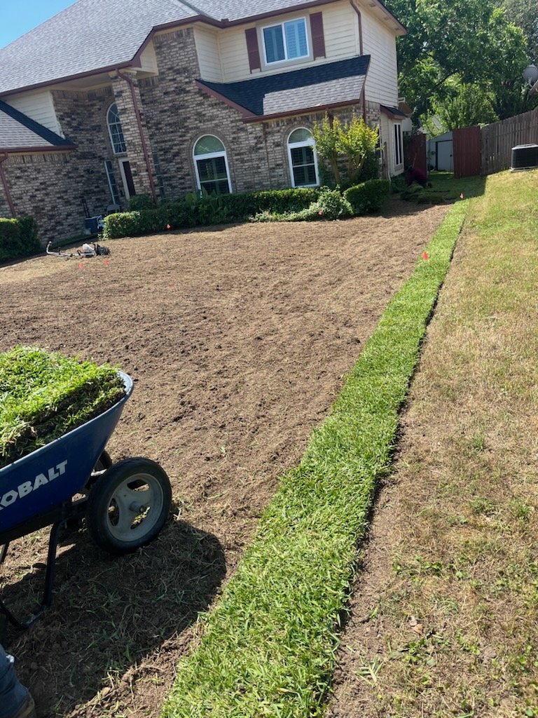 Prepared soil and a strip of sod beside a residential home
