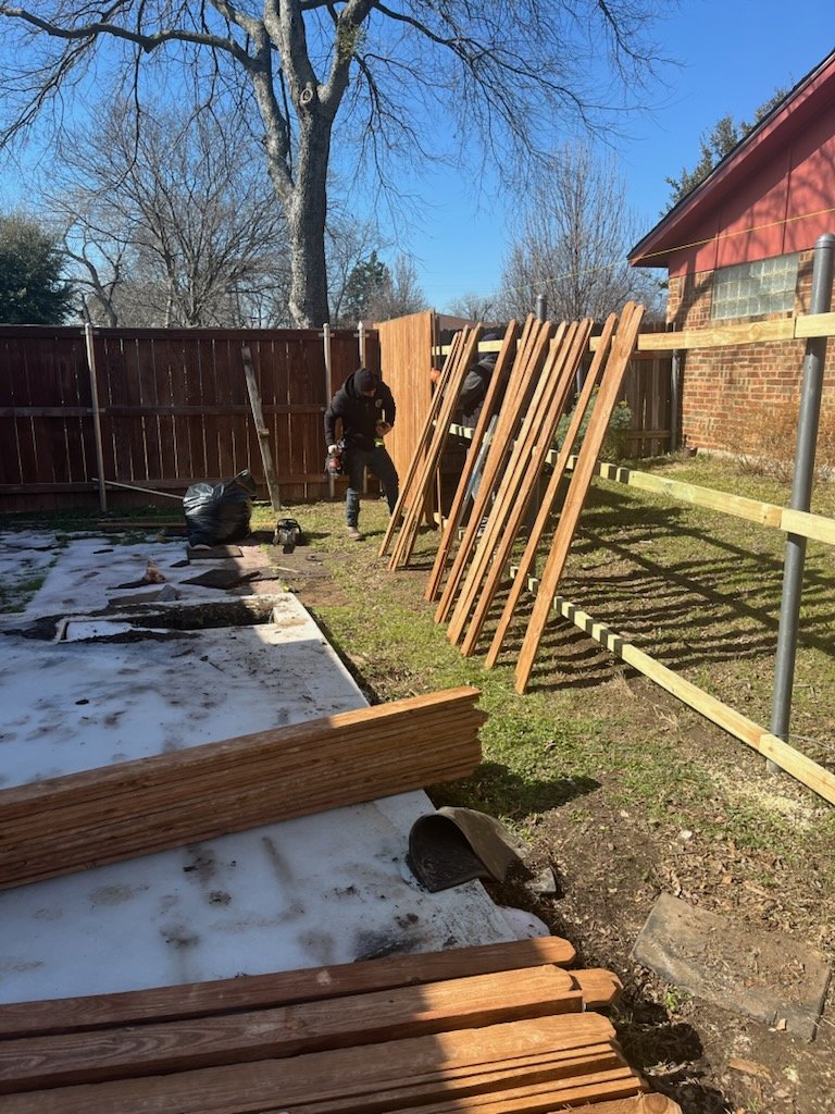Wooden boards staged beside fence rails